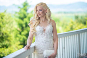 Елегантен портрет на булката в сватбената ѝ рокля, заснет на терасата. Снимка от сватба в Голф клуб "Равно поле", дело на сватбен фотограф Симеон Сълов.