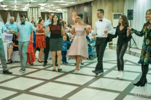 Гости на сватба танцуват в редица българско хоро на дансинга на Ресторант ЛАУРА в София. Сватбена фотография от Симеон Сълов.