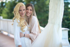 Топъл семеен момент между булката и нейната дъщеря, които се прегръщат на терасата. Емоционална снимка от сватба в Голф клуб "Равно поле", заснета от сватбен фотограф Симеон Сълов.