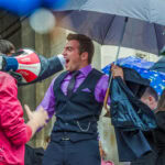 Емоционален абитуриент вика от радост под дъжда пред храм-паметник "Св. Александър Невски" в деня на своя абитуриентски бал.