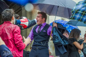 Емоционален абитуриент вика от радост под дъжда пред храм-паметник "Св. Александър Невски" в деня на своя абитуриентски бал.