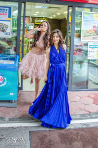 Две абитуриентки от Езиково училище Дорис Тенеди се забавляват, позирайки за снимка пред магазин в деня на бала си.