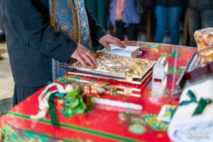 Близък план на ръцете на свещеника, положени върху светото евангелие по време на молитва за кръщението на Борис. Кадър от професионален фотограф за кръщене Симеон Сълов.