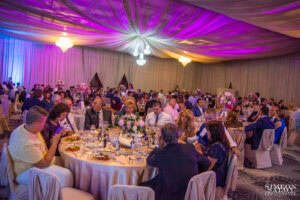 Широк кадър на балната зала в хотел Маринела, изпълнена с гости, които очакват младоженците на голямата сватба на Саня и Радослав, кадър на професионален сватбен фотограф Симеон Сълов.