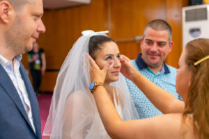 Кумата нежно бърше сълзите от емоция на булката Мирела по време на церемонията по граждански брак в ритуална зала Триадица. Кадър от професионален сватбен фотограф Симеон Сълов.