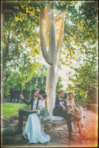 Непринуден момент на смях и разговор между младоженците Изабела и Христо и техните кумове, докато седят на голямата люлка, заснет от сватбен фотограф Симеон Сълов.