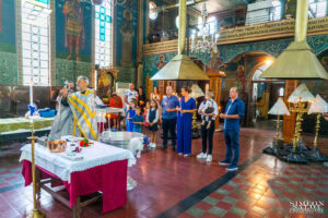 Свещеникът извършва ритуала по освещаване на водата в купела преди кръщението на Борис – кадър от фотограф за кръщене.