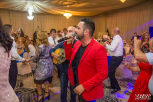 Гръцкият певец Андреас пее на живо за гостите, които танцуват на дансинга по време на голямата сватба на Саня и Радослав в хотел Маринела, кадър на професионален сватбен фотограф Симеон Сълов.