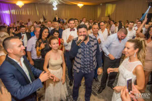 Тони Стораро пее на живо, заобиколен от препълнен дансинг с танцуващи младоженци и гости на пищната сватба в хотел Маринела, кадър на професионален сватбен фотограф Симеон Сълов.