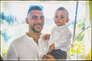 Щастлив баща държи своя син Светозар по време на тържеството за първия му рожден ден – семеен портрет, заснет от фотограф за детски рожден ден.