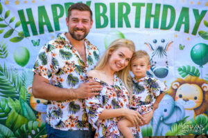 Класически семеен портрет на втория рожден ден на Антъни пред украса с животни, заснето от професионален фотограф за детски рожден ден в София.