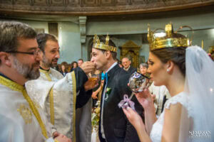 Свещеник дава причастие на младоженеца по време на сватбената церемония в храм „Света Параскева“.