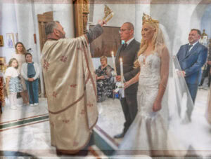 Свещеникът извършва ритуала по коронясване, държейки сватбената корона над главата на младоженеца Вальо. Кадър от сватбен фотограф Симеон Сълов.