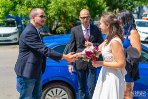 булката посреща гост и му стиска ръката пред ритуална зала Студентска