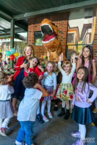 Деца с изрисувани лица позират с огромен надуваем динозавър на детския рожден ден на Краси – фотограф за детски рожден ден Симеон Сълов в София.