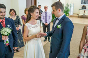 Сватбен фотограф Обредна зала "Средец": Булката слага сватбената халка на пръста на младоженеца по време на ритуала за граждански брак. Кадър от Симеон Сълов.