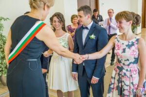 Сватбен фотограф Обредна зала "Средец": Длъжностното лице се ръкува с младоженеца, поздравявайки го за сключения граждански брак. Кадър от Симеон Сълов.