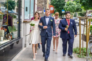 Сватбен фотограф Обредна зала "Средец": Младоженците и кумовете вървят по улицата в центъра на София, отправяйки се към ритуала за граждански брак. Кадър от Симеон Сълов.