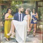 Винтидж сватбена снимка – Людмил носи булката Раймона на ръце пред обредна зала Студентска, докато върху тях се сипят ориз и листенца