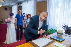 Кумът се подписва като свидетел на сватбения ритуал в Обредна зала „Сердика“.