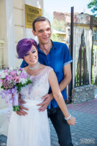 Младоженците се усмихват пред обредна зала „Сердика“ в София – сватбена фотография от Симеон Сълов