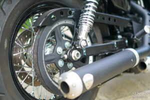 Детайлна мото фотография на задното колело, амортисьора и ауспуха на Harley-Davidson Sportster, заснета от фотограф Симеон Сълов