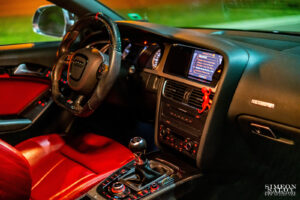 Автомобилна фотография на интериора на Audi S5 с червен кожен салон и спортен волан, заснета от Симеон Сълов