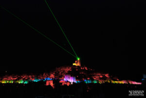 Драматично червено осветление на крепостта Царевец, символизиращо историята.